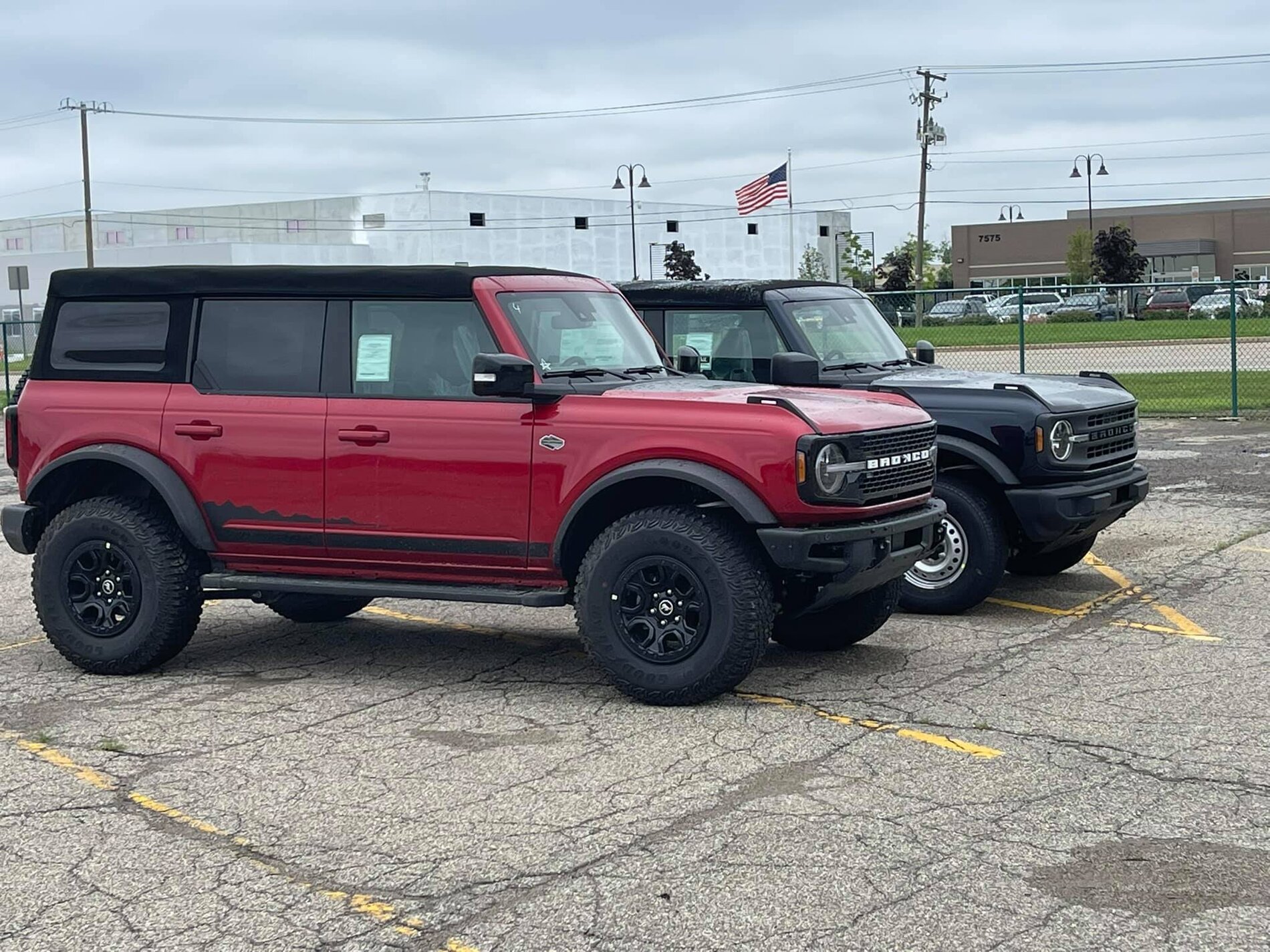 Ford Bronco Wildtrak vs Base Bronco 4-Door Side-by-Side Shows Height and Equipment Difference 2021 Bronco -- Rapid Red Wildtrak + Shadow Black Base 4-Doors 2