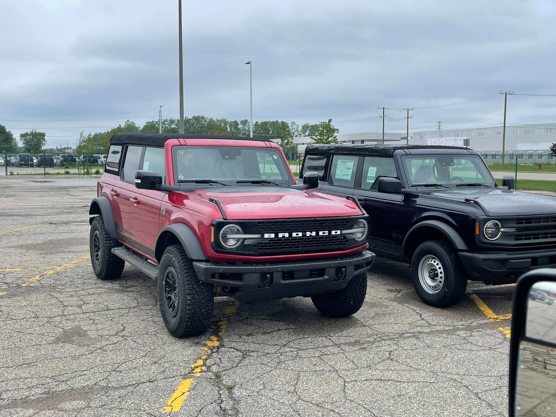 Ford Bronco Wildtrak vs Base Bronco 4-Door Side-by-Side Shows Height and Equipment Difference 2021 Bronco -- Rapid Red Wildtrak + Shadow Black Base 4-Doors 3